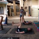 Pilates coach Leonard Lubbe holding up the leg of a client who is lying on her back at his private training gym in Sunwich Port