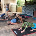 Pilates coach Leonard Lubbe watches while his class are lying on their backs arching upwards