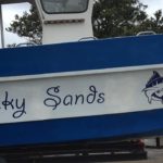 fishing boat Lucky Sands has blue stripes on white in Shelly Beach