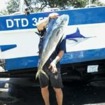 Fisherman holding has fish caught on Lucky Sands in Shelly Beach