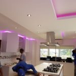 White kitchen with pink lighting and gas hob