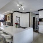 White kitchen table with builtin hob in modern openplan kitchen