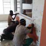 Three painters prepping a wall for waiting