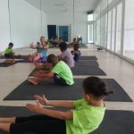 Young people doing exercises on mats indoors with coach Leonard on the South Coast KZN