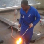 Nickluk Projects handyman on roof with blowtorch doing waterproofing