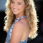 Kylie Loveday wearing a halterneck white and blue dress with her long golden locks falling over her shoulders