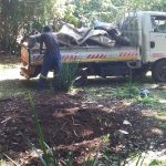 Worker loading rubble onto an open flatbed truck