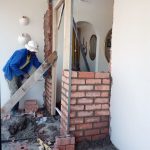 Fixall worker installing door frame while building new walls to extend a home