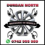 White poster with black edge and has a wheel in the middle with tools crossing over it showing the name Mechanic on Wheels in the centre and the Whatsapp contact number