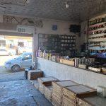 Reception area of hardware Maclear shop has shelves with smaller products and packs of tiles on the floor at the counter