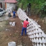 A white retaining wall being erected on the ground outside a home by Indlu Yegagu Iyanetha Primary Cooperative building construction Durban