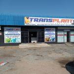 Shop front of Transplant Pneumatic and Hydraulic services and replaits shows a large parking area, big windows with signs on them as well as at the top of the entrance to the shop