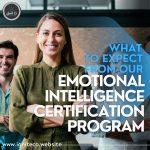 This poster to advertise the Emotional Intelligence Certification Program has these words written in large white letters with a darkened background with blue writing above it, saying What to expect from our" and a smiling lady, with her arms crossed and log brown hair, standing behind these words to the left, and a smiling man standing behind her. On the top left corner is the Ignite Co logo